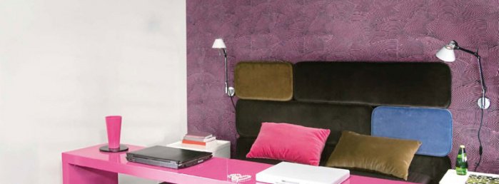 Kolorowe wnętrze, z różowym stolikiem oraz brązową kanapą.