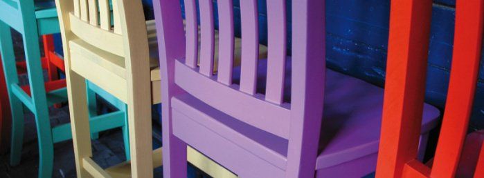 Krzesła pokryte farbą w różnych kolorach.